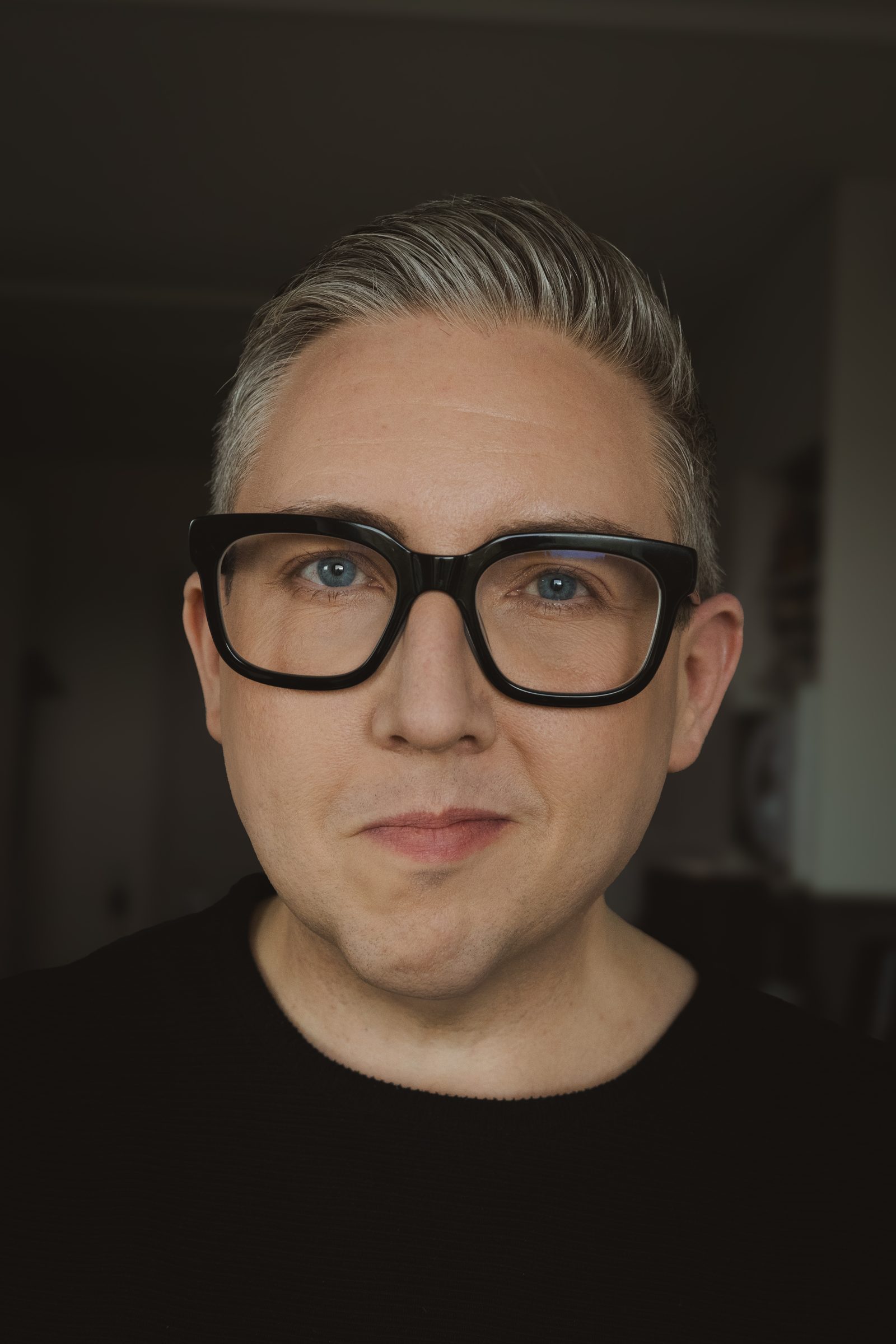 Porträtt av Joakim Kvist med svarta glasögon och svart tröja